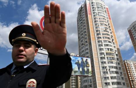 Un officier barre la route devant un immeuble résidentiel endommagé par une attaque de drones à Moscou, le 30 mai 2023 ( AFP / Kirill KUDRYAVTSEV )
