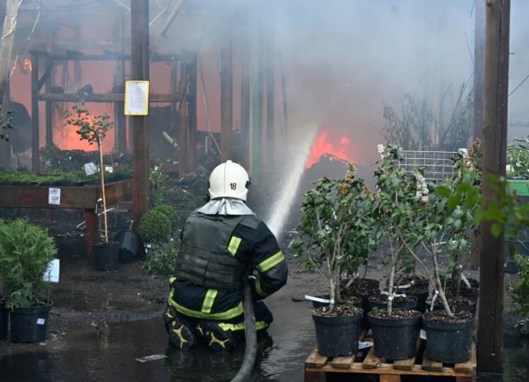 Un pompier ukrainien éteint un incendie dans un hypermarché après une frappe russe à Kharkiv, le 25 mai 2024 ( AFP / SERGEY BOBOK )
