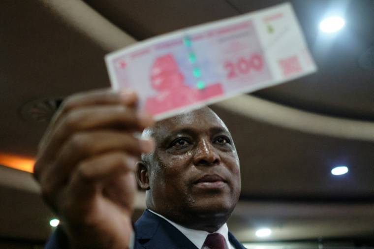 Un billet de 200 ZiG brandi par le gouverneur de la Banque de réserve du Zimbabwe à Harare, le 5 avril 2024 ( AFP / Jekesai NJIKIZANA )
