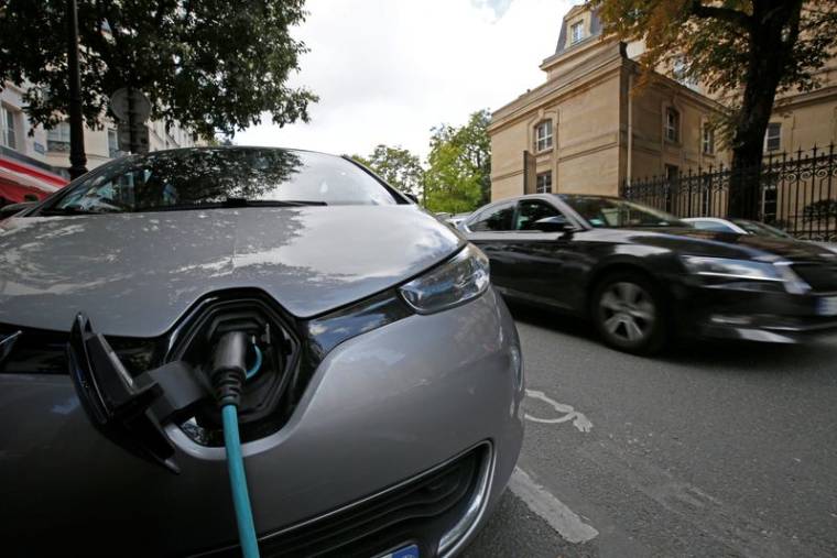 Une voiture électrique en train d'être rechargée dans une rue de Paris, en France