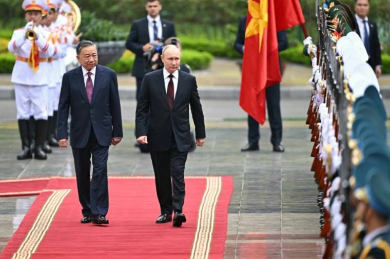 Le président russe Vladimir Poutine (centre), et son homologue vietnamien To Lam (gauche), lors d'une cérémonie d'accueil du premier, le 20 juin 2024, au palais présidentiel de Hanoï ( AFP / Manan VATSYAYANA )