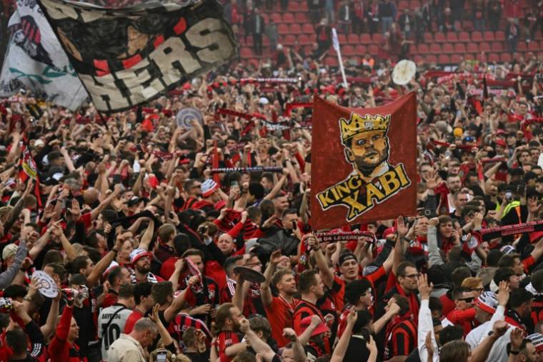 Les supporters du club de football du Bayer Leverkusen célèbrent la victoire de leur club en championnat d'Allemagne après sa victoire 5-0 contre le Werder Brême au stade de Leverkusen le 14 avril 2024. ( AFP / INA FASSBENDER )