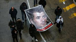 Des manifestants brandissent un portrait d'Yvan Colonna à Bastia pour lui rendre hommage, le 13 mars 2022 ( AFP / Pascal POCHARD-CASABIANCA )