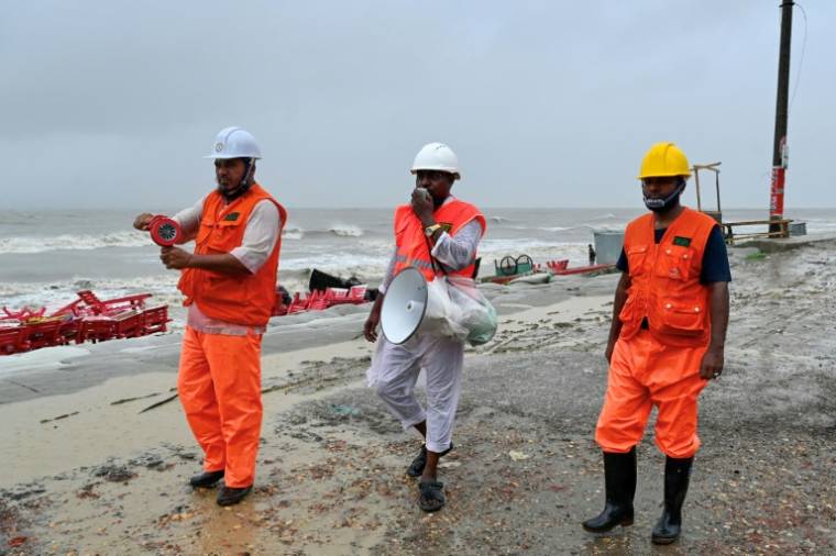 Les volontaires demandent avec un megaphone aux gens d'évacuer par mesure préventive à Kuakata le 26 mai 2024, avant l'arrivée dimanche soir du cyclone Remal au Bangladesh. ( AFP / Munir UZ ZAMAN )