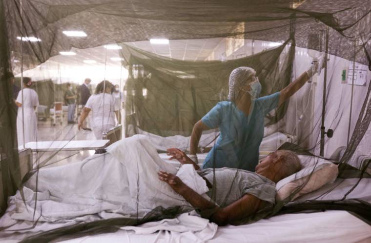 Une infirmière s'occupe d'un patient infecté par le virus de la dengue à l'hôpital Sergio Bernales de Lima, le 17 avril 2024 ( AFP / Juan Carlos CISNEROS )